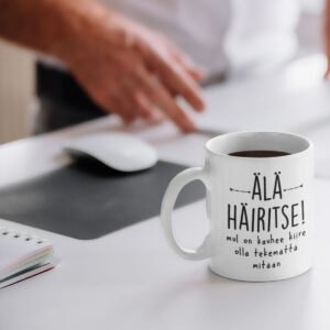 Valkoinen muki jossa teksti "Älä häiritse, mul on ihan hirvee kiire olla tekemättä mitään". Paskakaupalla painettu.