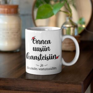 valkoinen muki jossa teksti "onnea uusiin haasteisiin ja ikuisiin vastatuuliin" ,paskakaupan muki